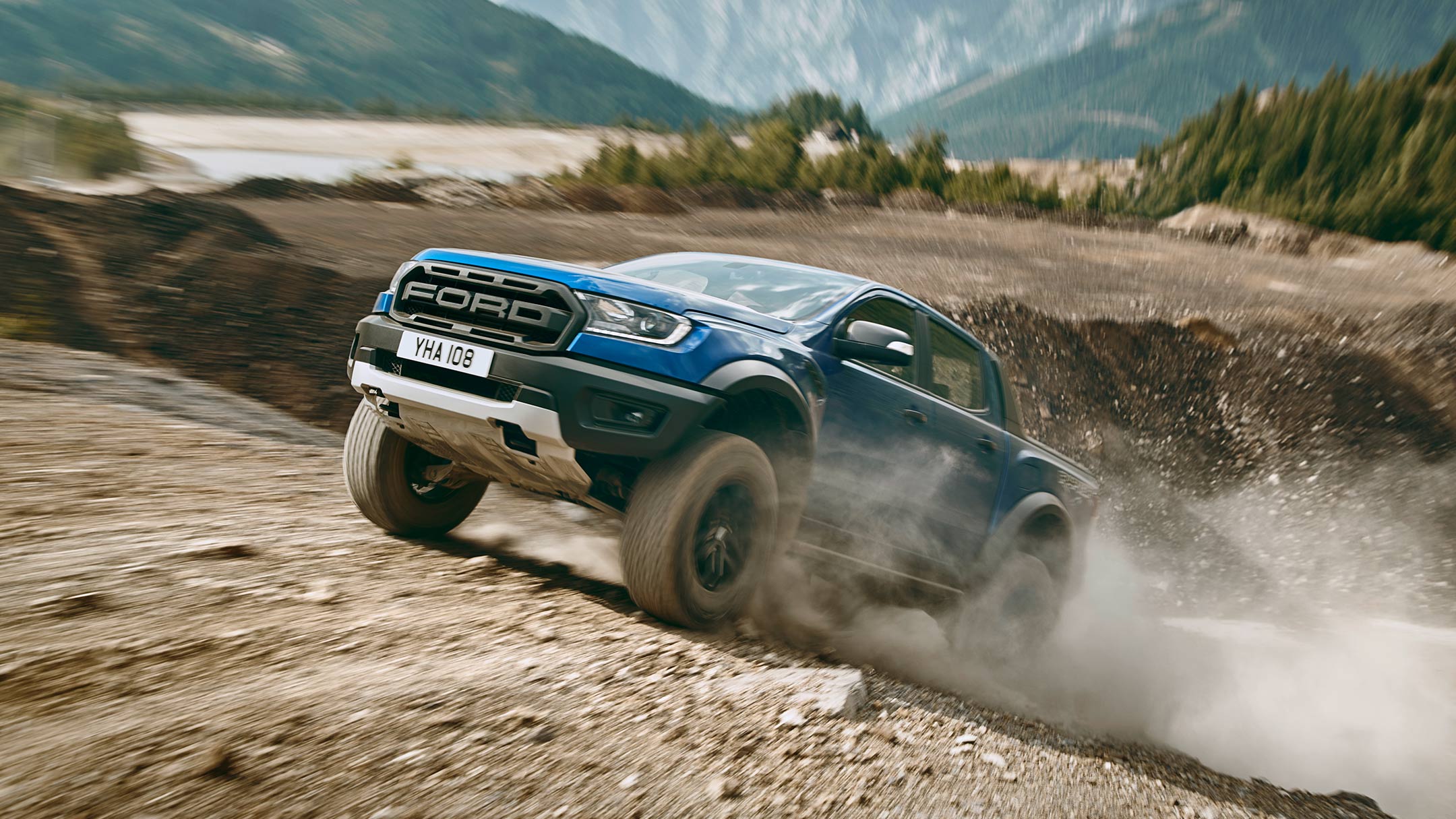 Blue Ford Ranger Raptor driving uphill off road