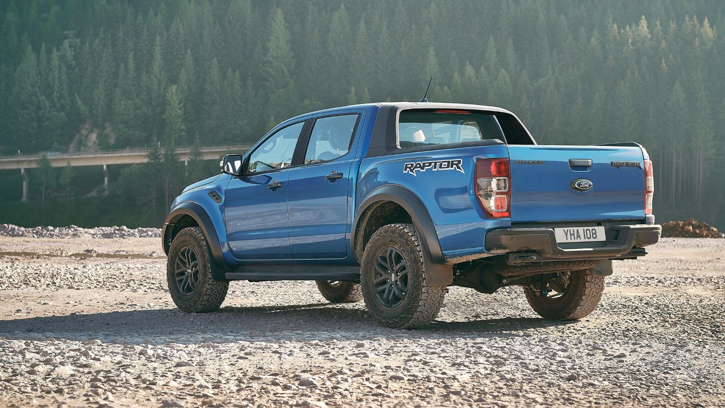 Blue Ford Ranger Raptor parked near forest off road