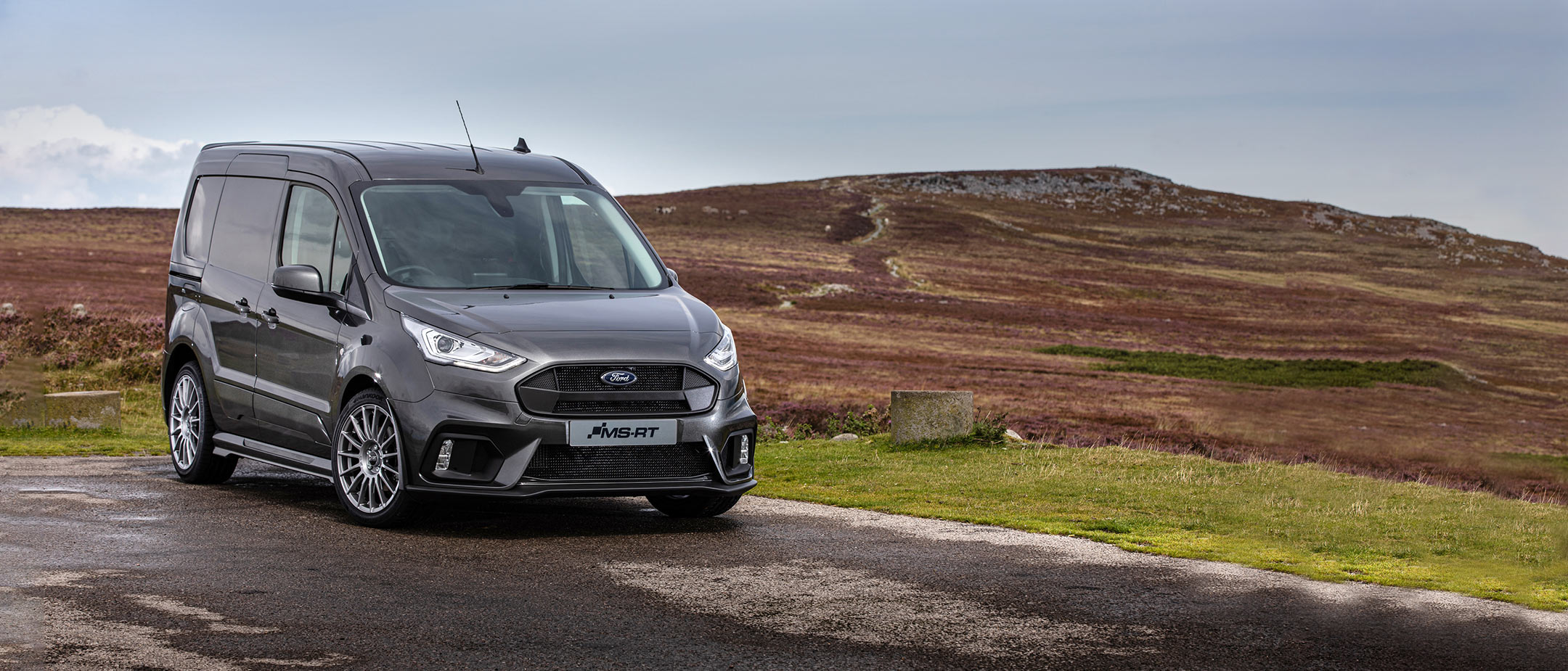 Black Ford Transit Connect MS-RT driving through the countryside