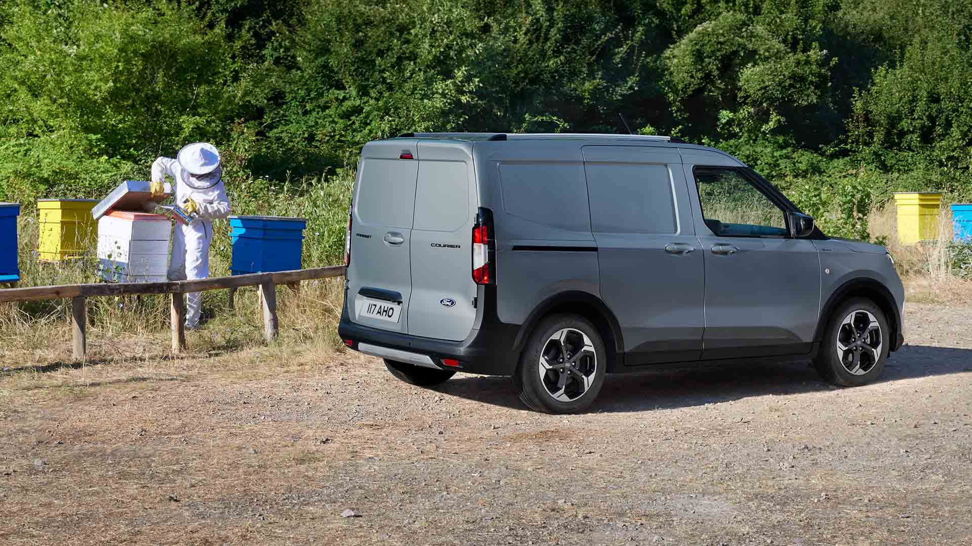 Apicultor lucrând lângă un nou Ford Transit Courier