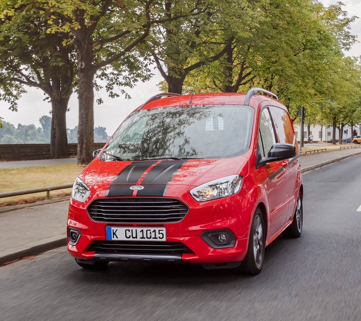 Red Ford Transit Courier Sport Van on city road