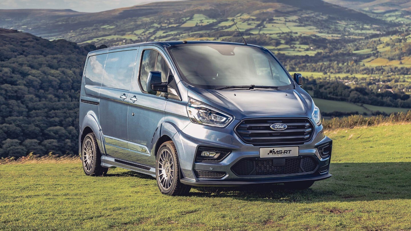 Ford Transit Custom MS-RT 3-quarter view with closed doors parked against a countryside background