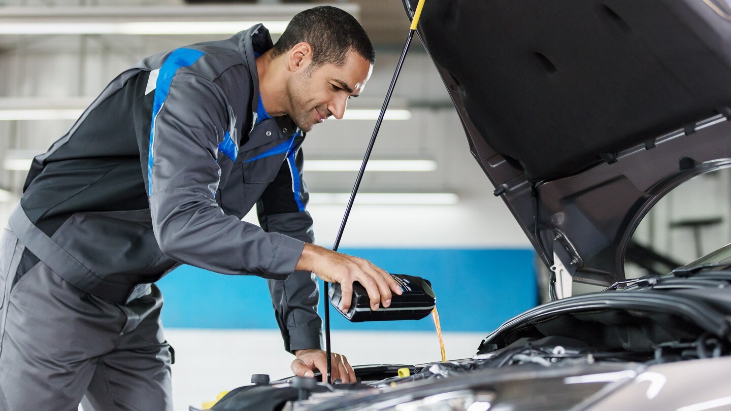 Technician filling up a car with an antifreeze
