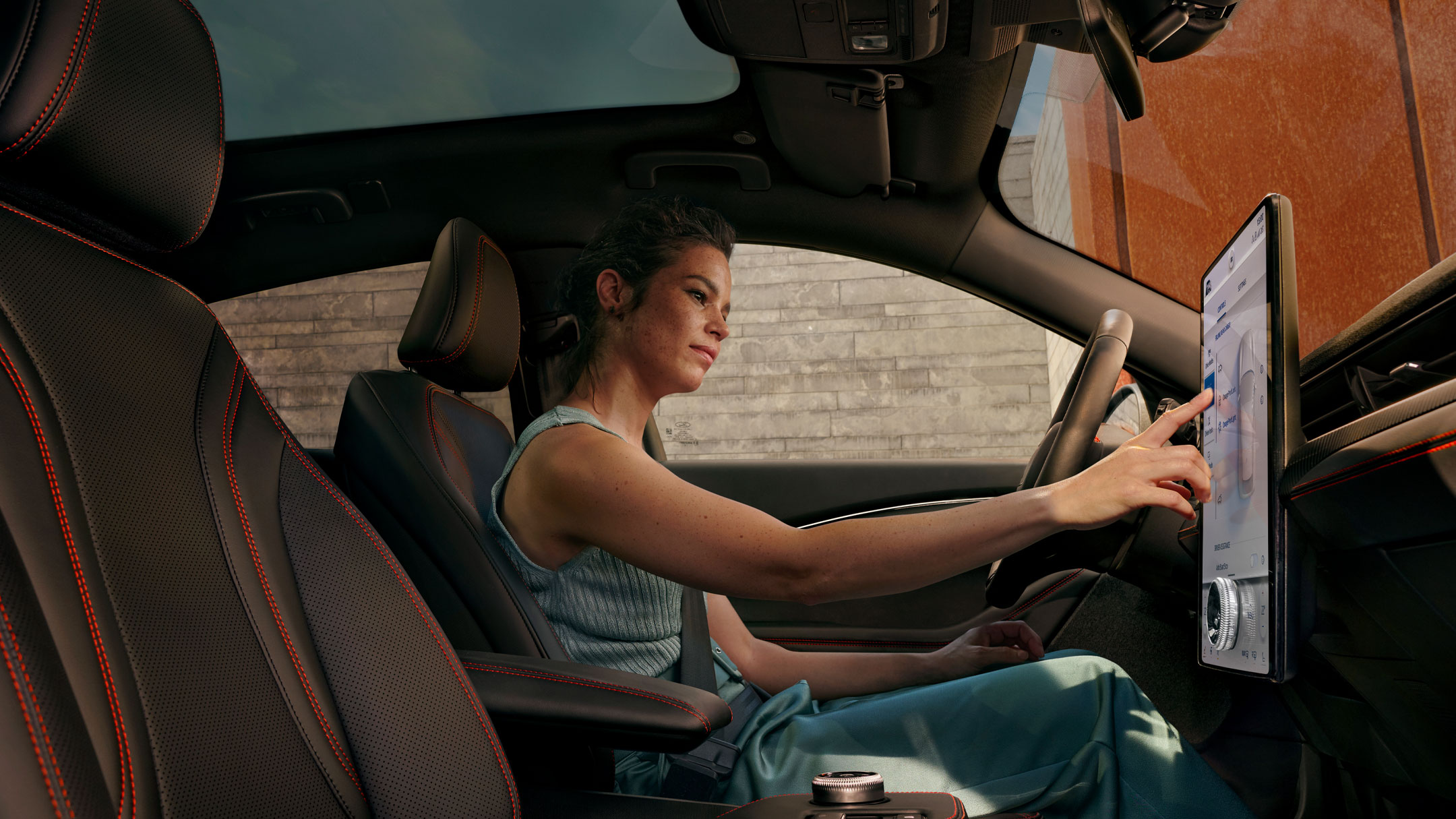 Woman using the central touchscreen in her Ford