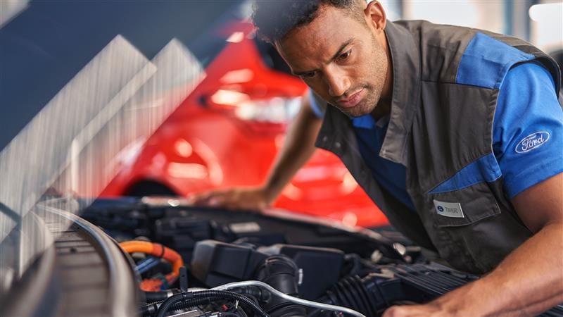 O persoană zâmbitoare primește cheile unui Ford Puma ST-Line verde, stând lângă ușa deschisă a șoferului.